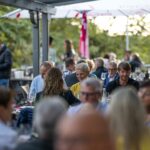 Menschen sitzen an den VIP Tischen des Wein am Stein Events