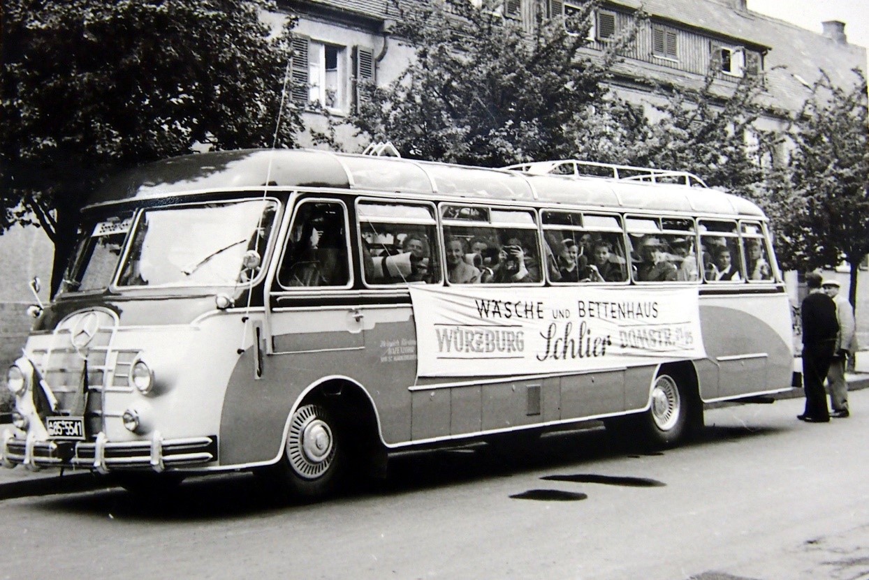 schwarz weiß Bild eines Busses mit dem Banner Wäsche und Bettenhaus Würzburg Schlier