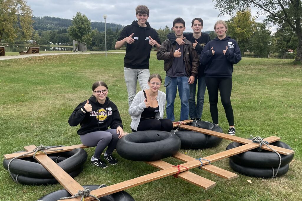 Die Auszubildenden bauen mit Brettern und Autoreifen gemeinsam Boote, in der Hoffnung, dass diese nicht untergehen