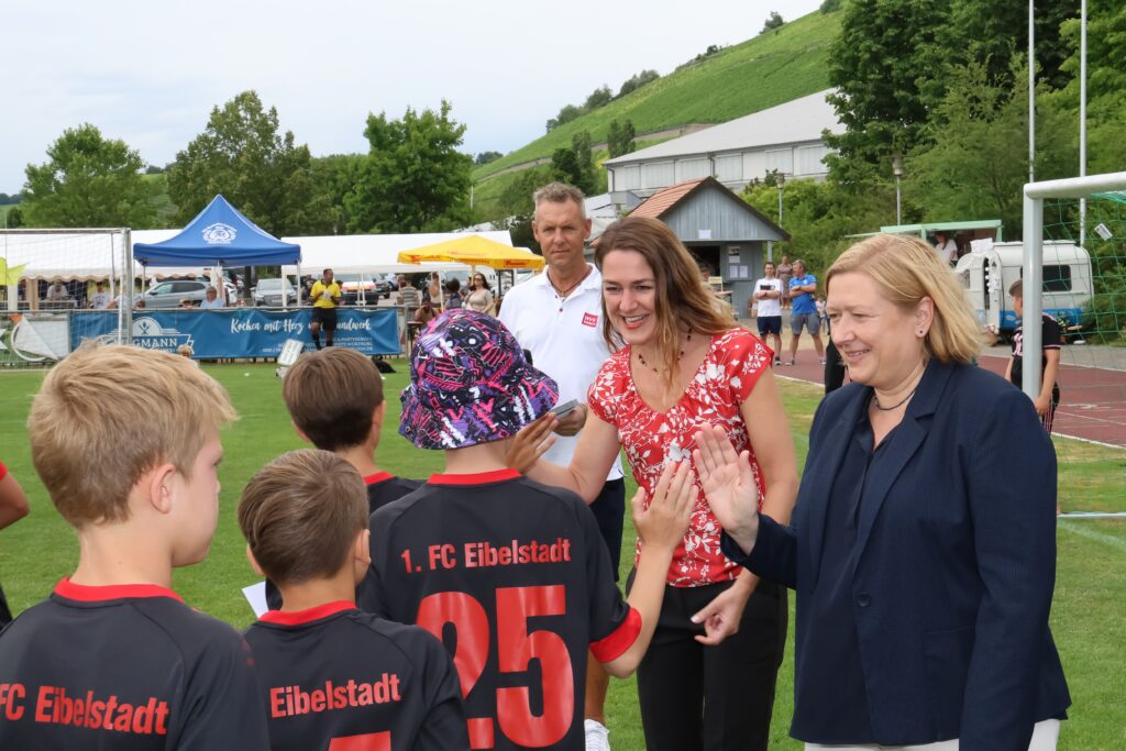 Die WVV-Geschäftsführerin Dörte Schulte-Derne und die Bürgermeisterin Dr. Sandra Vorlová von der Stadt Würzburg klatschen bei der Siegerehrung mit den Fußballkids ab